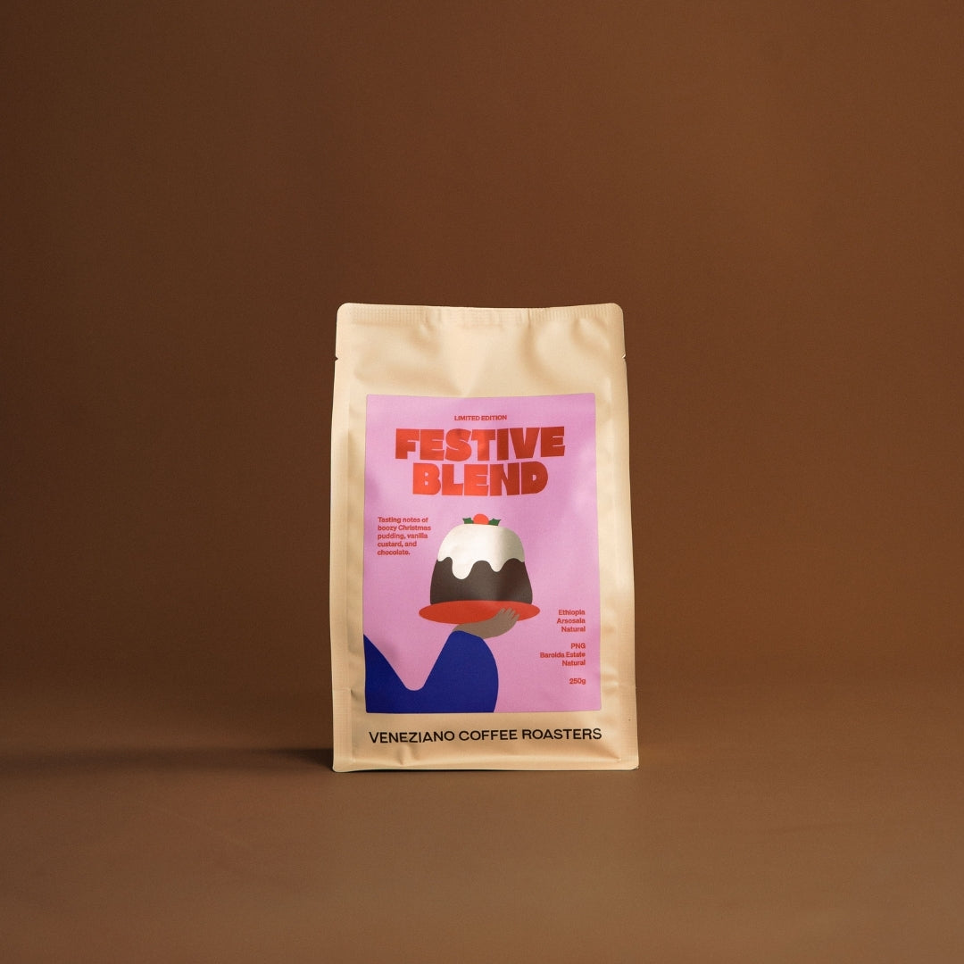 Coffee package labeled 'Festive Blend' by Veneziano Coffee Roasters on a brown background