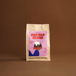 Coffee package labeled 'Festive Blend' by Veneziano Coffee Roasters on a brown background